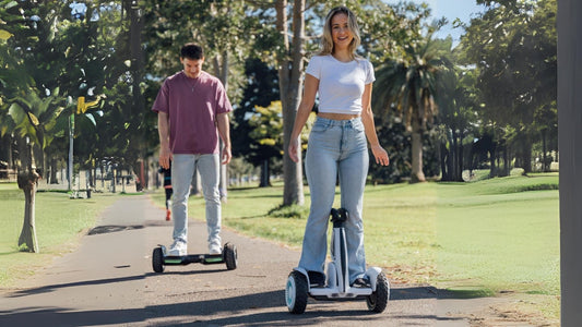 Two person riding rideo hoverboard in park