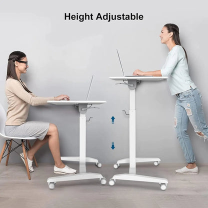 Two women in casual and business attire demonstrate the height adjustability of a mobile white desk in a comparison setup, highlighting its versatility for sitting or standing use.