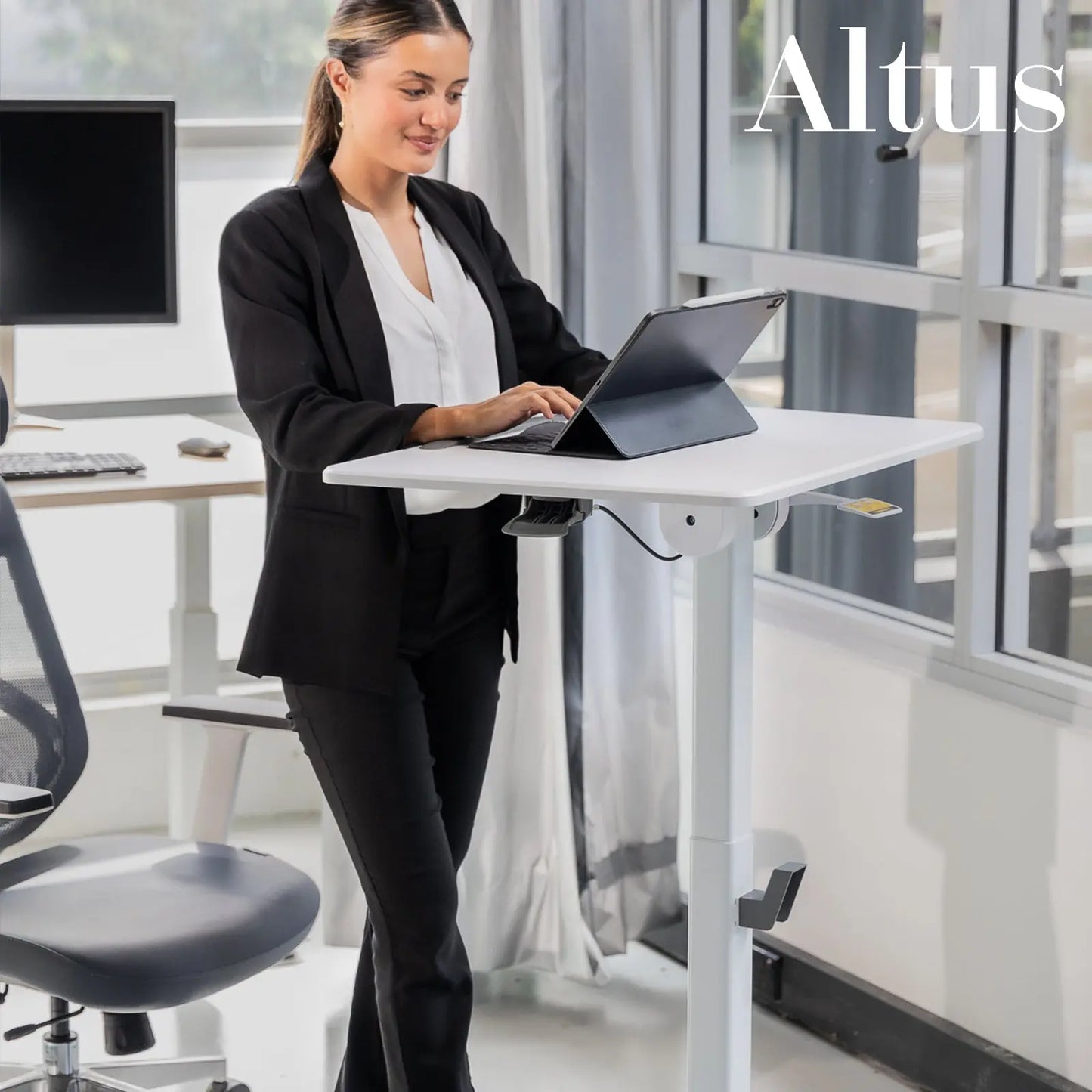 A professional woman using a laptop at a white mobile desk in an office, demonstrating the desk’s practical application for active working environments.