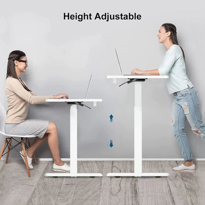 Two people, one seated and one standing, using identical white height-adjustable desks in a light, airy space.