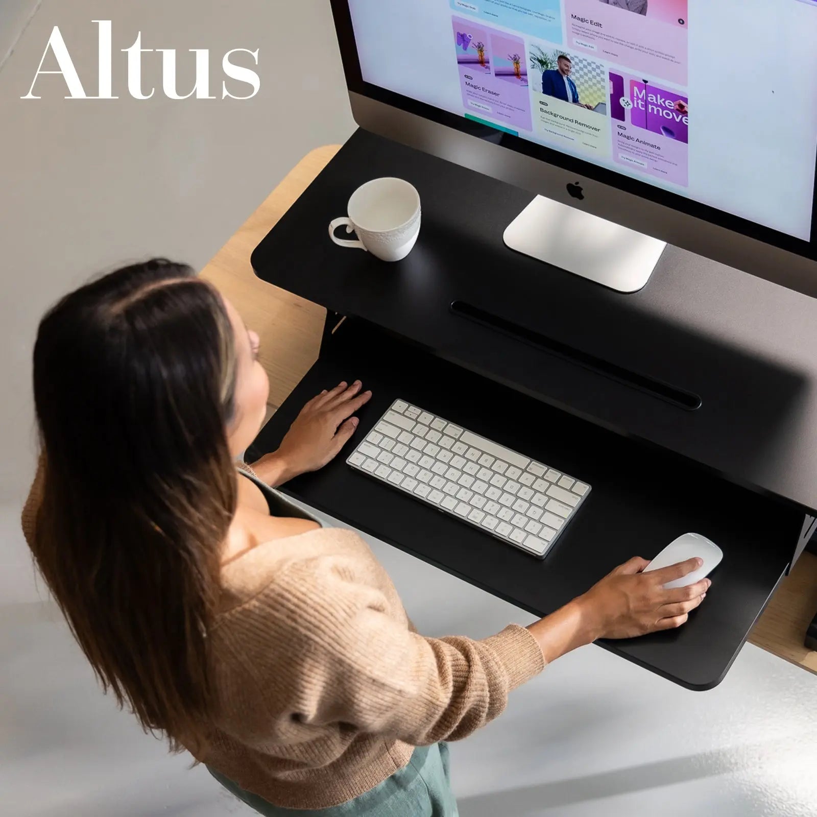 Overhead view of a black sit-to-stand desk converter with a desktop computer, showcasing ergonomic design and desk space.