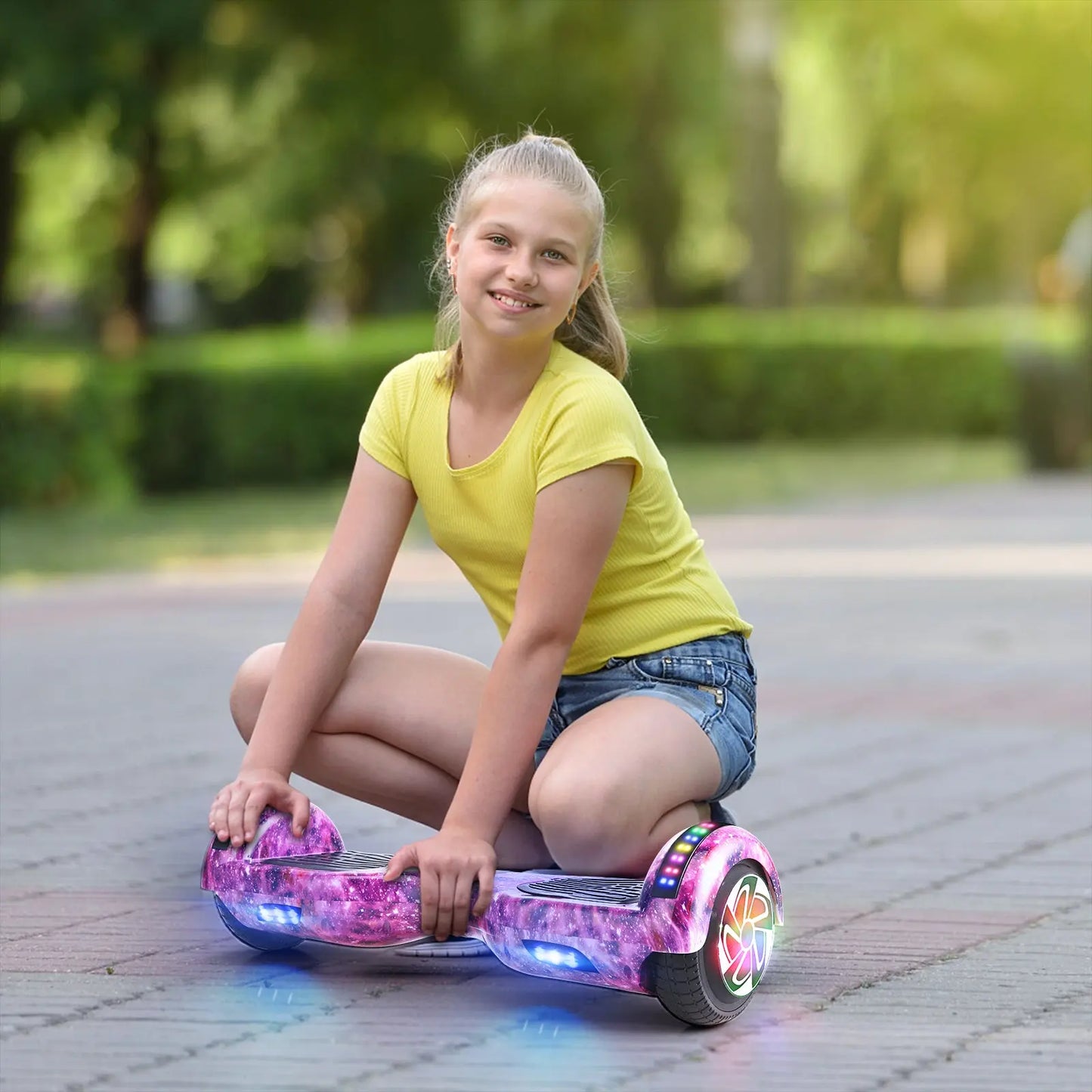 Photo of a young girl sitting next to her RIDEO Hoverboard in Purple Galaxy, highlighting the hoverboard’s appeal to children and teens