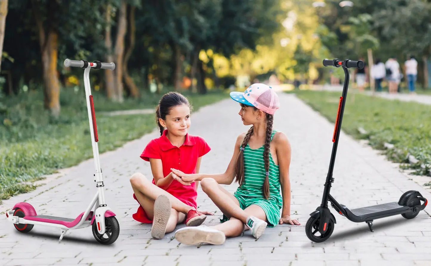 Two girls sitting with scooters