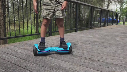 A little boy playing with a RIDEO Q3-C on outdoor wooden decking.