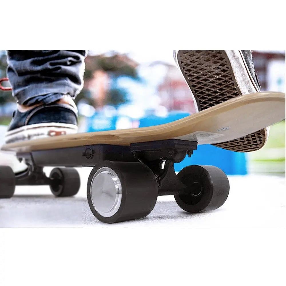 Close-up of an electric skateboard in motion on the street, showing the bottom and wheels.