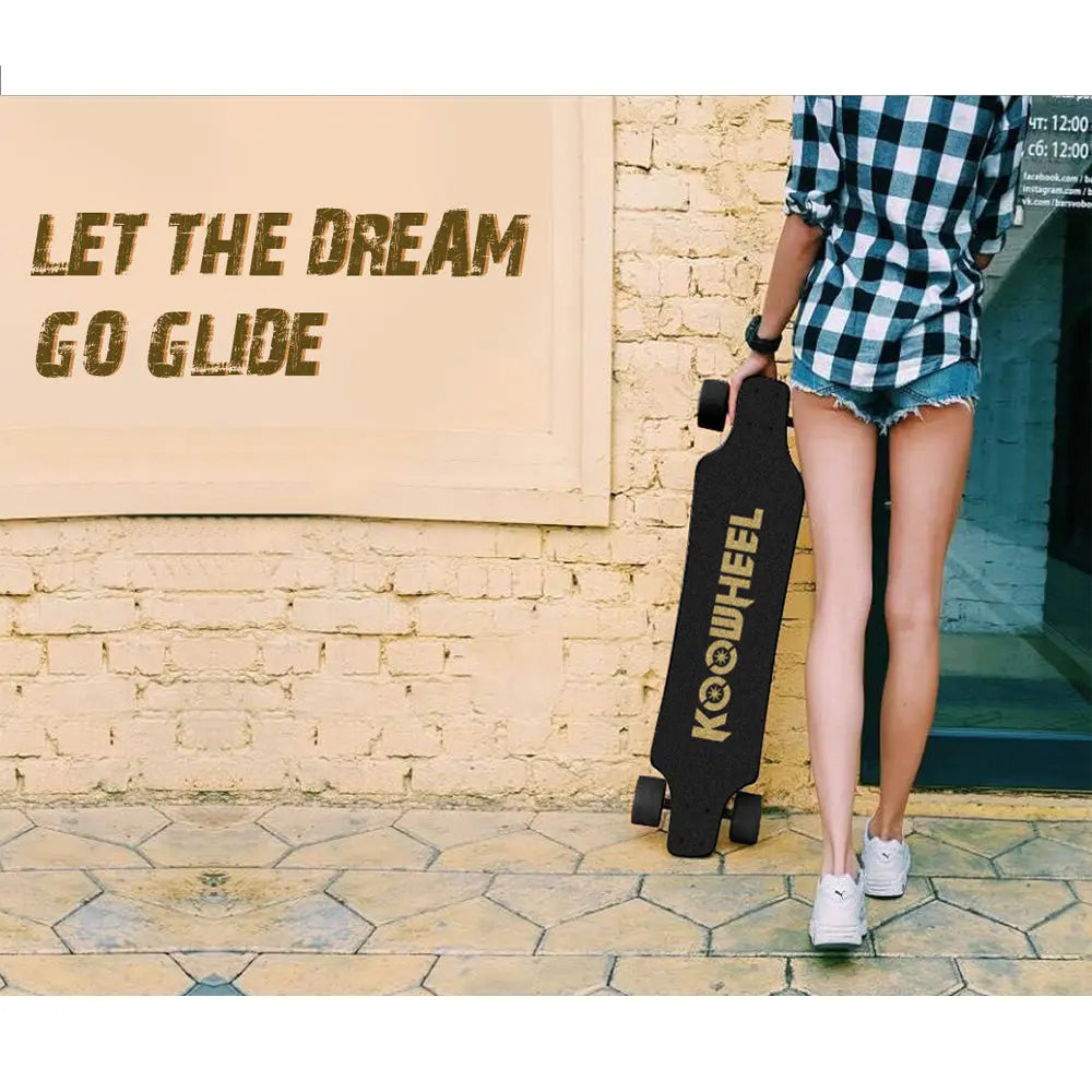 Young woman standing by a wall holding a Koowheel longboard: A young woman dressed in casual summer attire holds a black Koowheel longboard. The background features a textured wall and a sign that reads "Let the dream go glide."